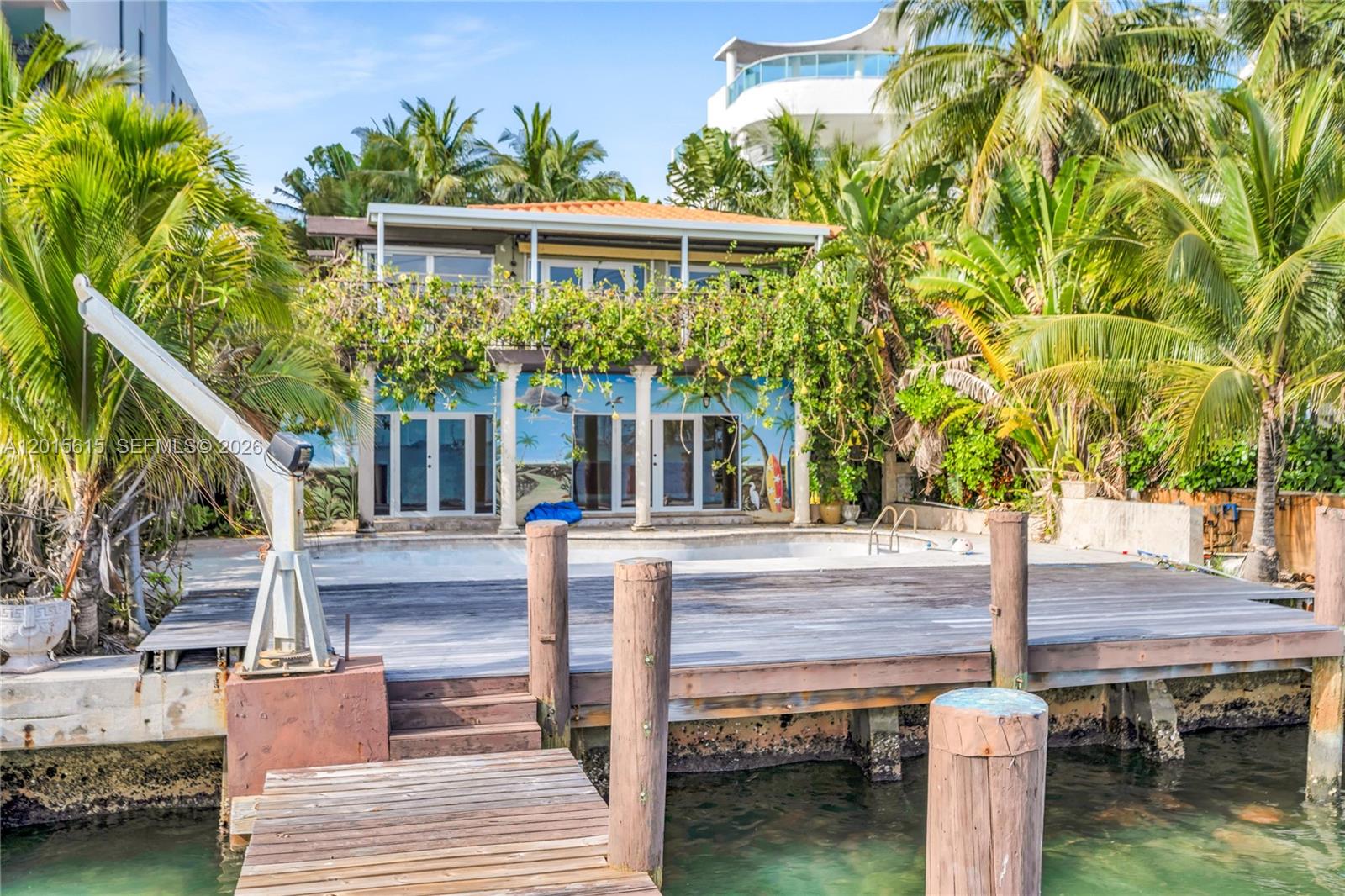 A waterfront house features a wooden deck, a swimming pool, and a painted mural exterior — 1920 Bay Dr, Miami Beach FL 33141, MIAMI BEACH, FL