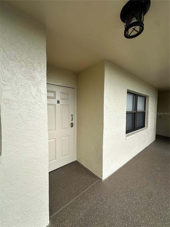 A white front door and a window are visible on a covered exterior walkway — 800 COVE CAY DRIVE UNIT 4F, CLEARWATER, FL