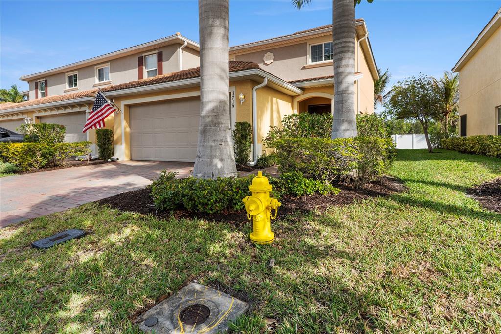 A yellow fire hydrant sits on the lawn in front of a two-story suburban house — 3719 CROFTON COURT, FORT MYERS, FL