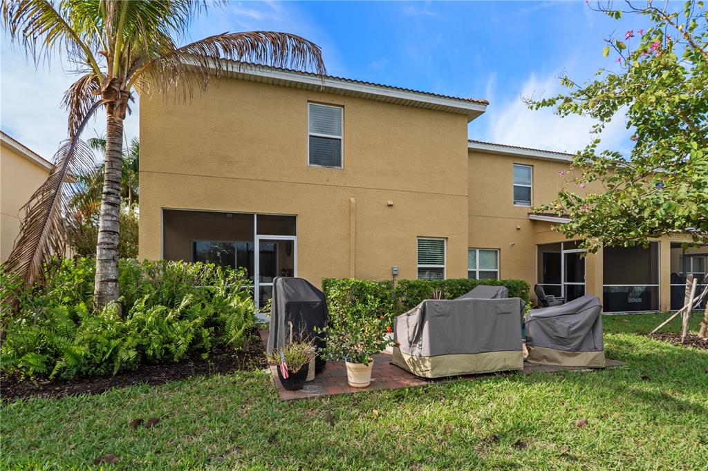 The exterior of a two-story tan stucco house features a patio with covered furniture — 3719 CROFTON COURT, FORT MYERS, FL
