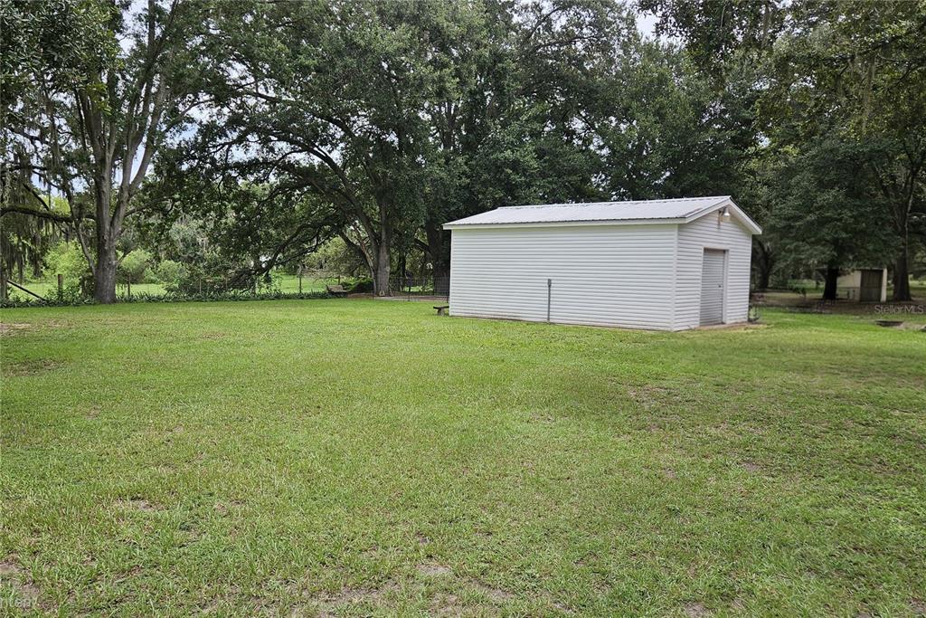 A single-story manufactured home with gray siding sits on a large, grassy lot — 5136 SHEPARD LANE, POLK CITY, FL