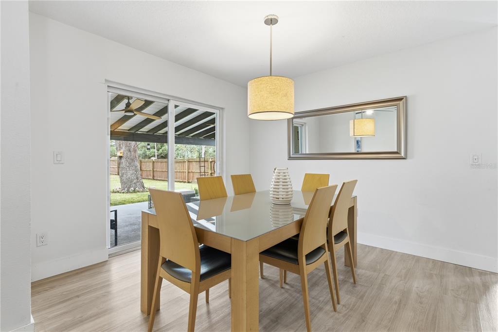 A dining room features a glass-topped table, six wooden chairs, a pendant light, and sliding doors — 1389 PONCE DE LEON BOULEVARD, WINTER SPRINGS, FL