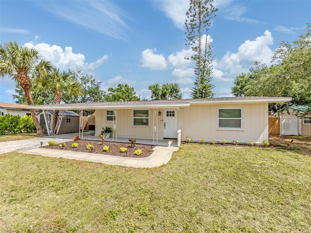 A single-story house with light-colored siding, a covered front porch, and a grassy yard — 929 CYPRESS AVENUE, VENICE, FL