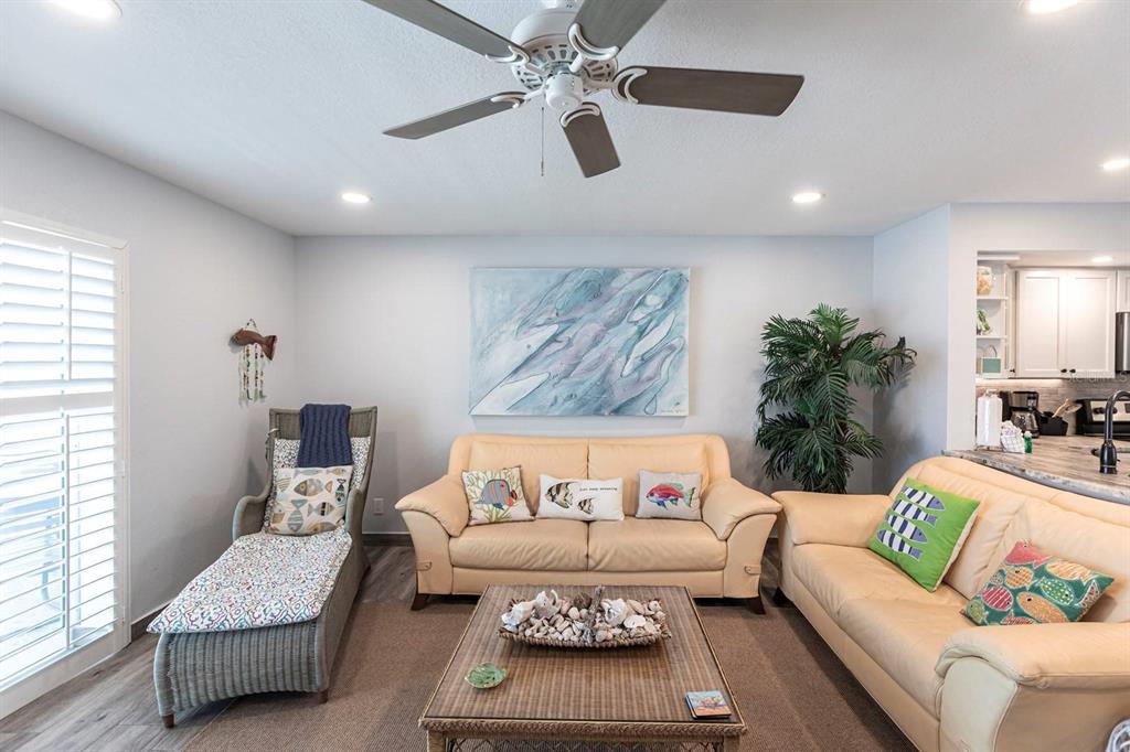 A living room features two beige sofas, a chaise lounge, and a central coffee table — 6154 MIDNIGHT PASS ROAD UNIT 202, SARASOTA, FL