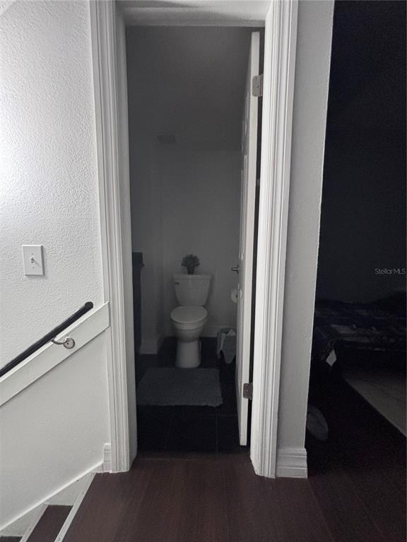 A small bathroom with a toilet is visible through an open doorway near a staircase — 4515 LA CAPRI COURT, TAMPA, FL