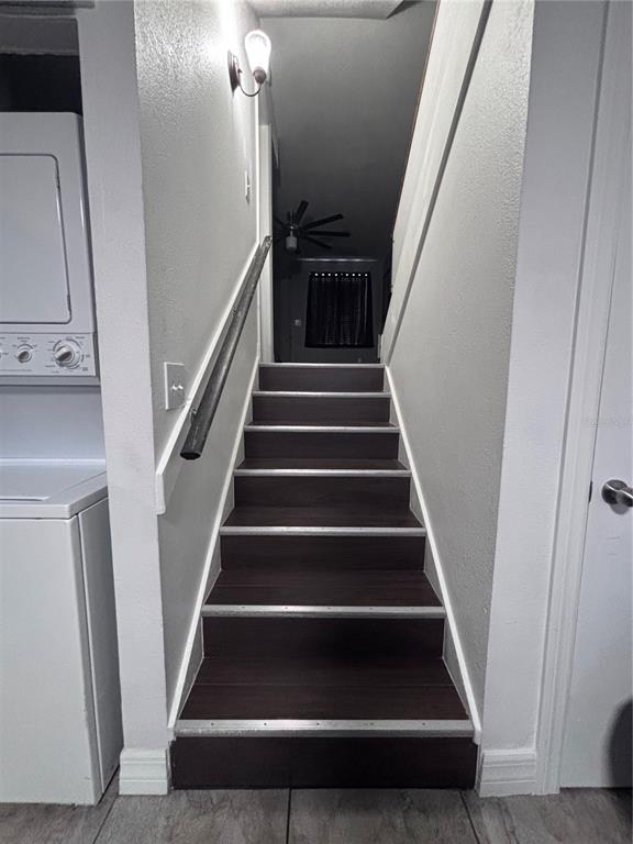 A staircase with dark wood treads and a metal handrail leads to an upper level — 4515 LA CAPRI COURT, TAMPA, FL