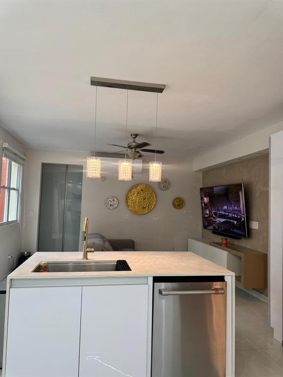 A modern kitchen island with a stainless steel sink and dishwasher faces a living area — B7 BRIGHTON COUNTRY CLUB, DORADO, PR