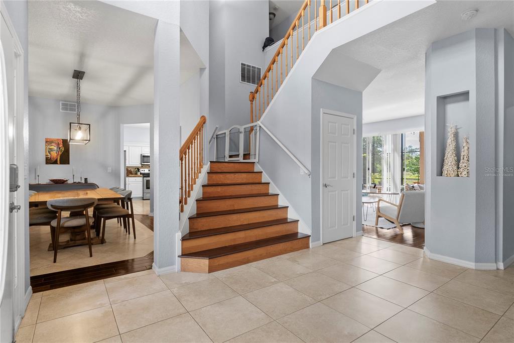 A foyer features a wooden staircase, tile flooring, and an adjacent dining area — 2264 STONE CROSS CIRCLE, ORLANDO, FL