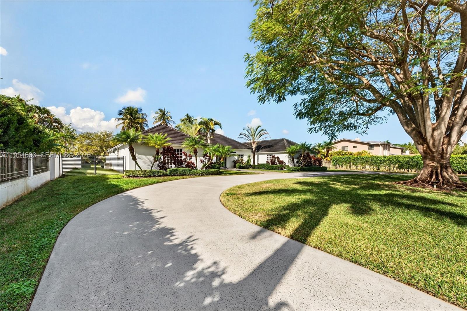 A curved concrete driveway leads to a single-story house surrounded by palm trees and grass — 3000 SW 130th Ave, Miami FL 33175, MIAMI, FL