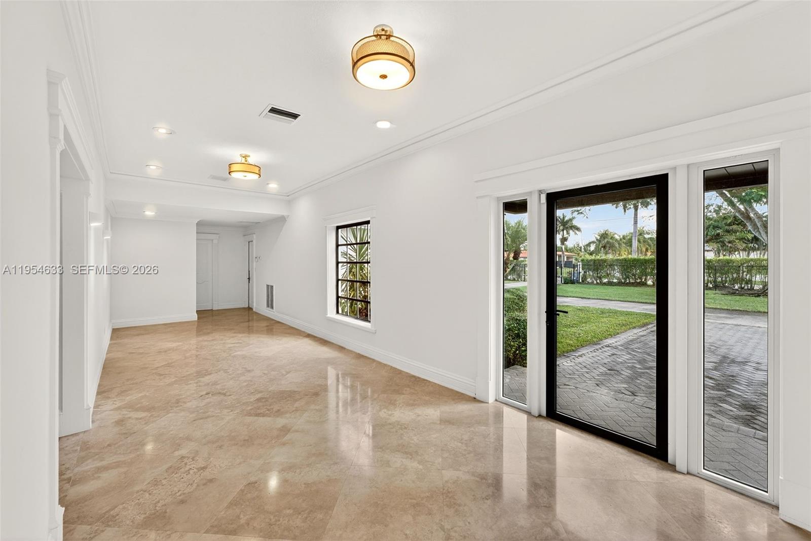 A bright, empty room features polished tile floors, recessed lighting, and glass exterior doors — 3000 SW 130th Ave, Miami FL 33175, MIAMI, FL