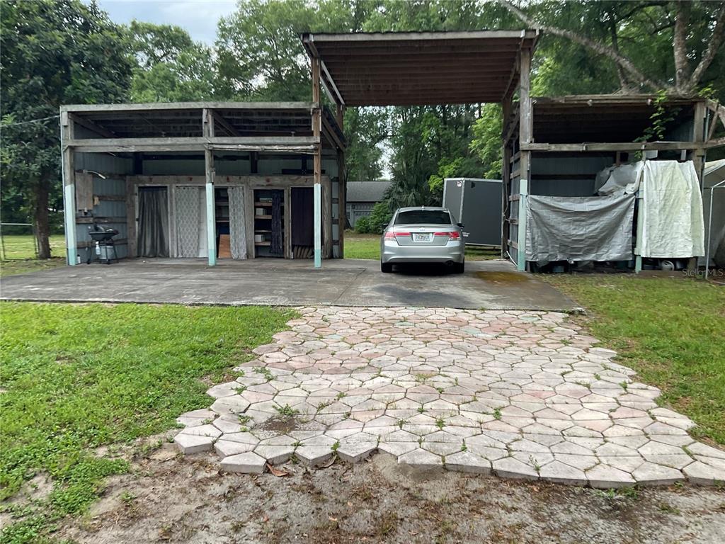 A silver sedan is parked under a large, open-sided wooden carport with concrete flooring — 360 S LAKEVIEW DRIVE, LAKE HELEN, FL