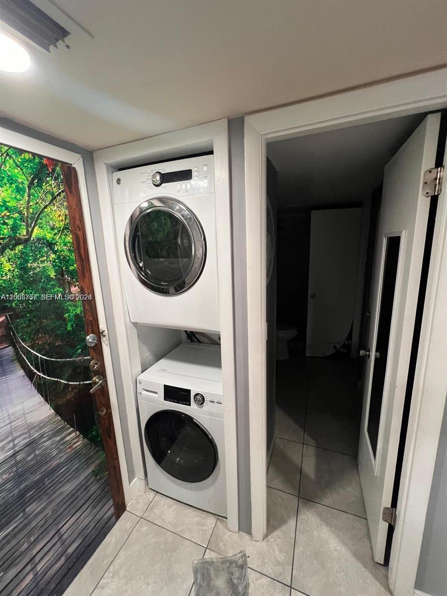 A stacked washer and dryer unit is installed in a closet next to a doorway — 488 NW 165th St Rd # 610, Miami FL 33169, MIAMI, FL