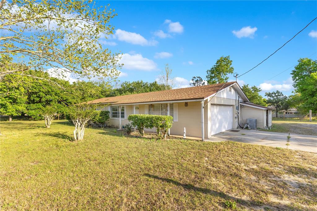 A single-story beige house with a brown shingled roof and an attached garage — 4550 CHANDLER ROAD, APOPKA, FL