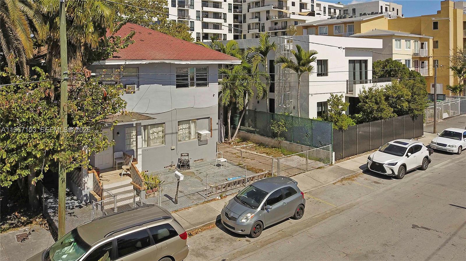 An exterior view of a two-story gray house with a red roof and fenced yard — 767 SW 2nd St, Miami FL 33130, MIAMI, FL