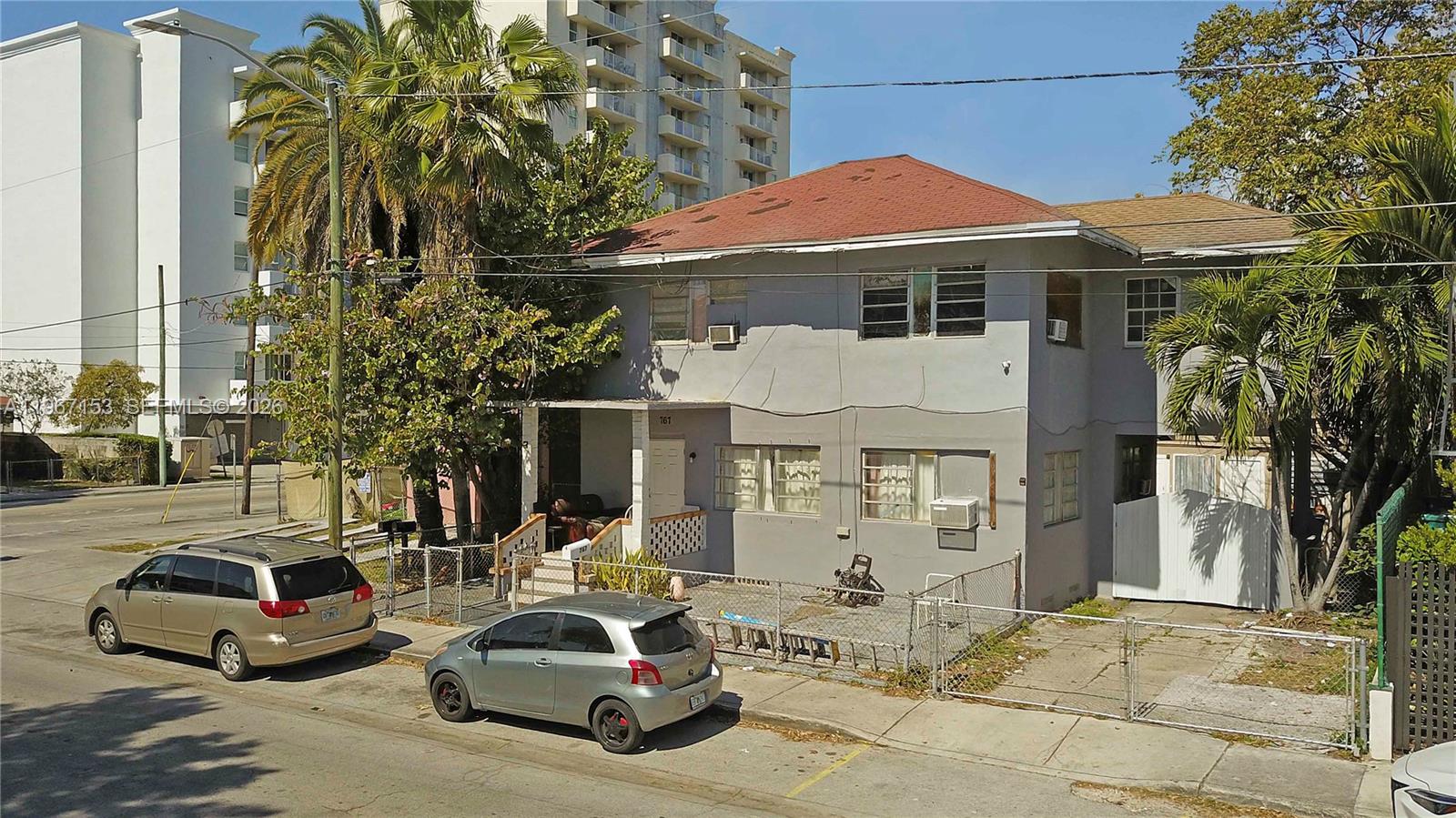 A two-story gray stucco building with a red roof sits behind a chain-link fence — 767 SW 2nd St, Miami FL 33130, MIAMI, FL