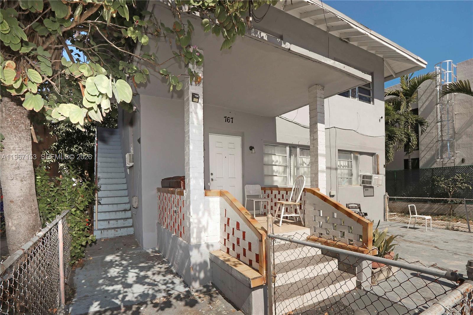 A two-story gray building features a front porch with brick columns and a staircase — 767 SW 2nd St, Miami FL 33130, MIAMI, FL