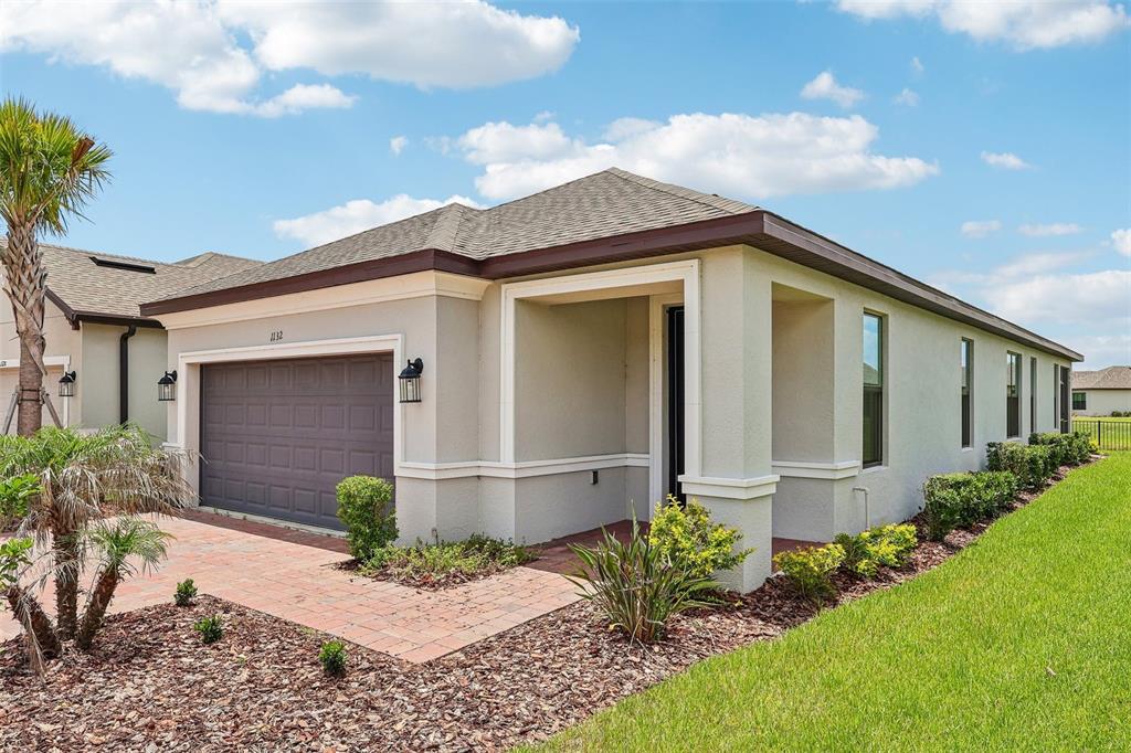An aerial view of a suburban house with a paved driveway at sunset — 1132 VIA GALUPPI STREET, KISSIMMEE, FL