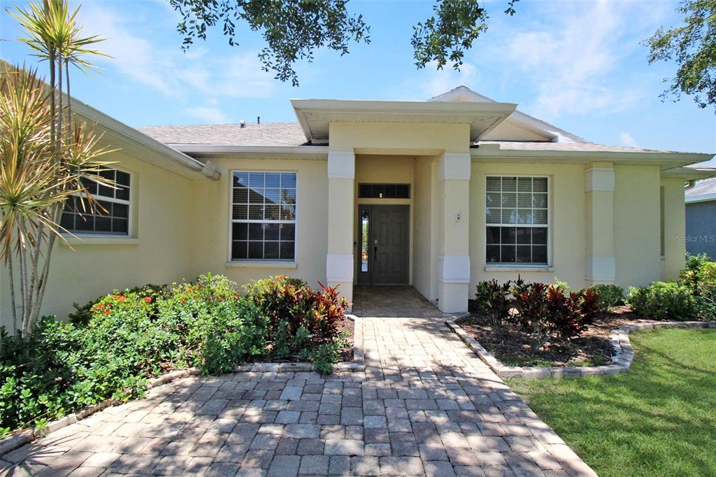 A single-story house with a paved walkway leading to a covered front entryway — 4815 77TH STREET E, BRADENTON, FL