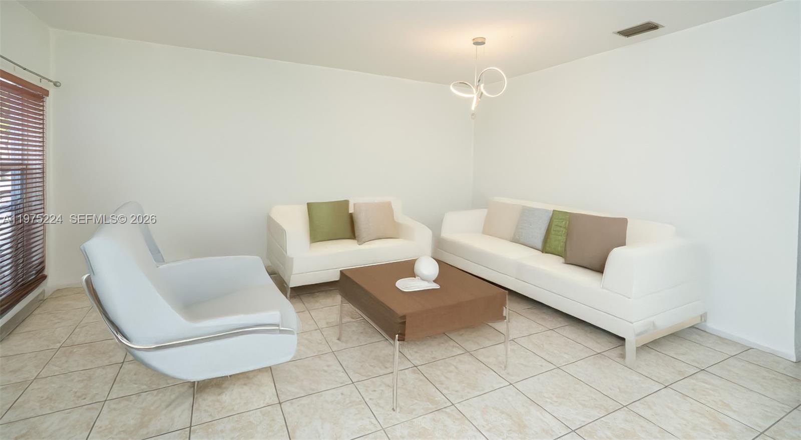A living room features white sofas, a brown coffee table, and light-colored tile flooring — 14046 SW 49th St # 16, Miramar FL 33027, MIRAMAR, FL