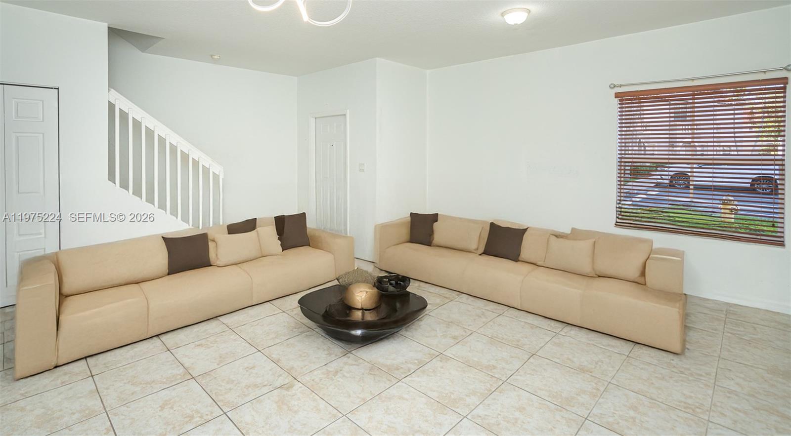 A living room features two beige sofas, a dark coffee table, and tiled flooring — 14046 SW 49th St # 16, Miramar FL 33027, MIRAMAR, FL