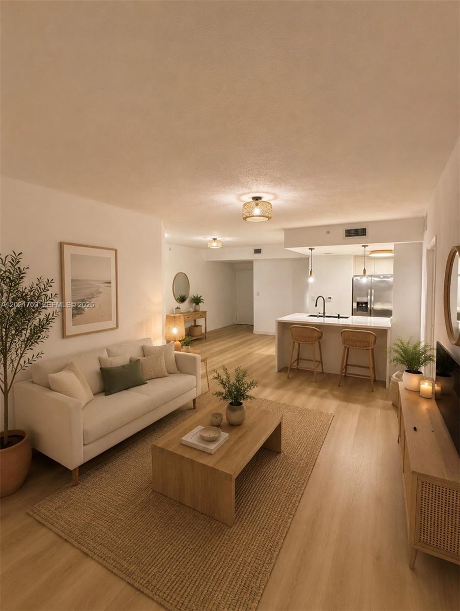This is a rendering of an open-concept living room and kitchen with light wood flooring — 275 NE 18th St # 910, Miami FL 33132, MIAMI, FL