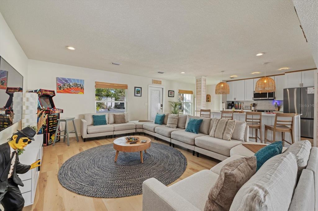 A spacious open-concept living room features a large sectional sofa, round rug, and kitchen island — 2069 BOUGAINVILLEA STREET, SARASOTA, FL