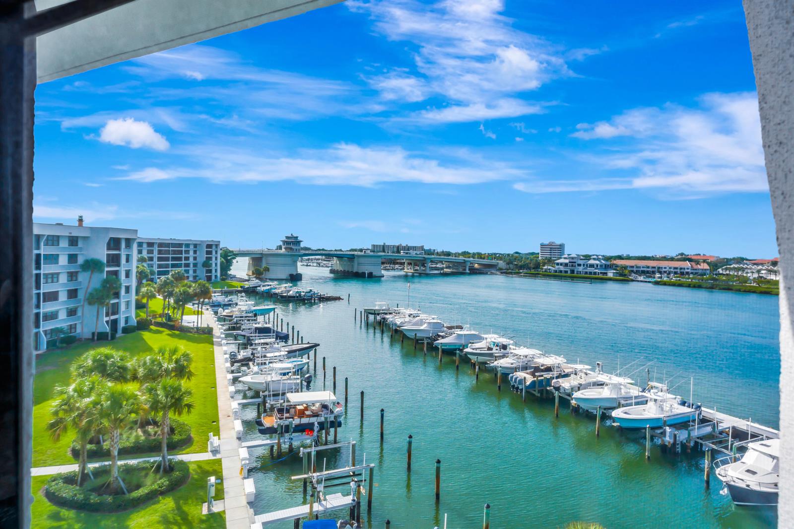 A high-angle view shows a marina with docked boats, a bridge, and waterfront buildings — 1648 Jupiter Cove Drive # 608b, Jupiter FL 33469, JUPITER, FL