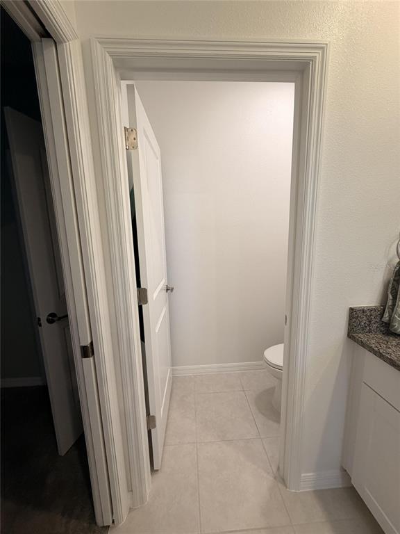 A view through a doorway into a small bathroom with a toilet and tile flooring — 10805 FANNING SPRINGS COURT, TAMPA, FL