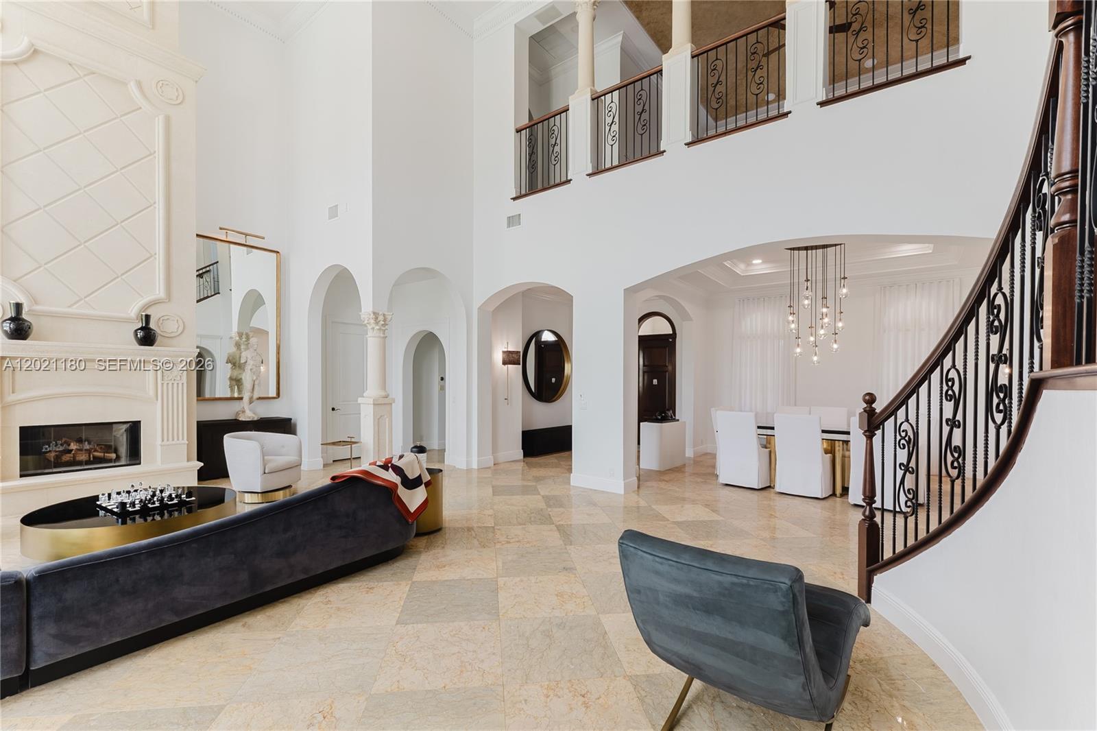 A spacious, high-ceilinged living and dining area features marble floors, a fireplace, and a staircase — 7290 Lemon Grass Dr, Parkland FL 33076, PARKLAND, FL