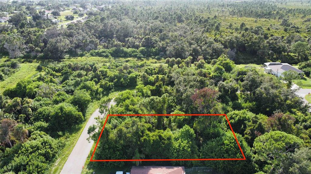 An aerial view shows a rectangular plot of land outlined in red amidst dense vegetation — IRONDALE RD, NORTH PORT, FL