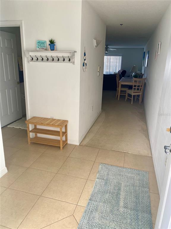 An entryway with tile flooring leads to a carpeted living and dining area — 5300 S ATLANTIC AVENUE UNIT 3502, NEW SMYRNA BEACH, FL