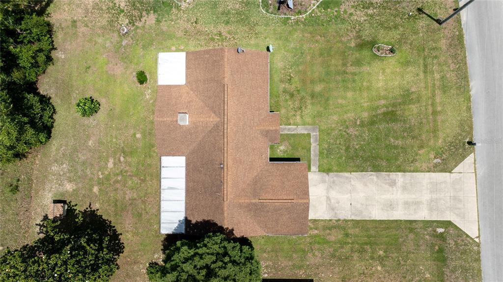 An aerial view shows a house with a brown roof, a driveway, and surrounding lawn — 15191 NE 9TH STREET, WILLISTON, FL