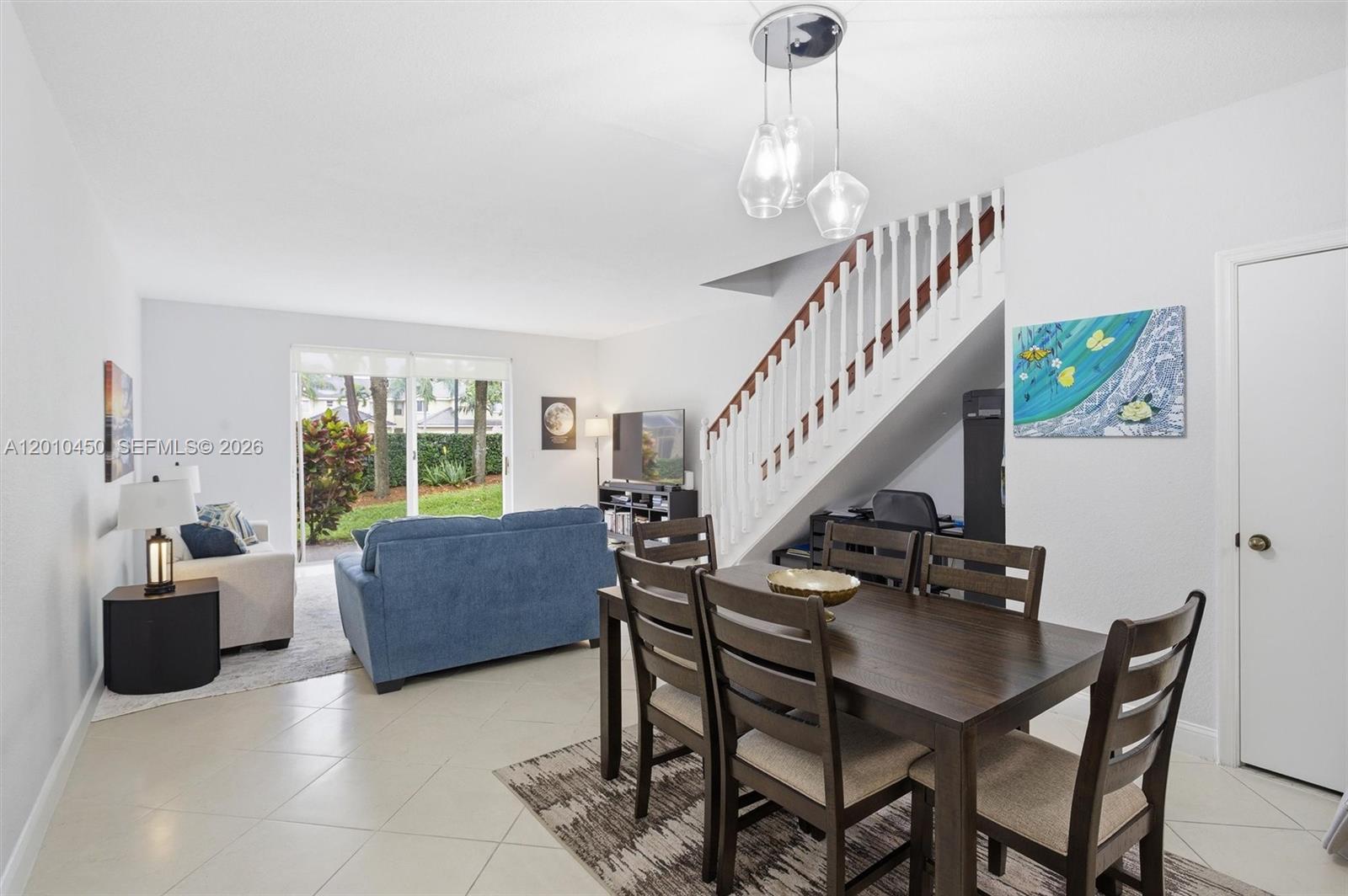 A dining area with a wooden table and chairs sits beside a living room — 2132 Bahia Ln, Weston FL 33327, WESTON, FL