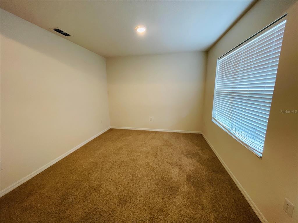 An entryway with tiled flooring leads to a carpeted living area and a hallway beyond — 975 SERCHIO STREET, HAINES CITY, FL