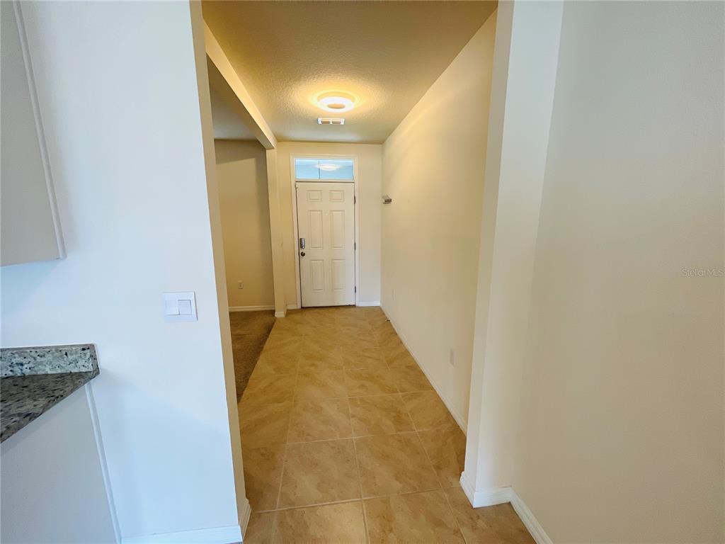 An empty bedroom features beige walls, brown carpeting, and a window with white blinds — 975 SERCHIO STREET, HAINES CITY, FL