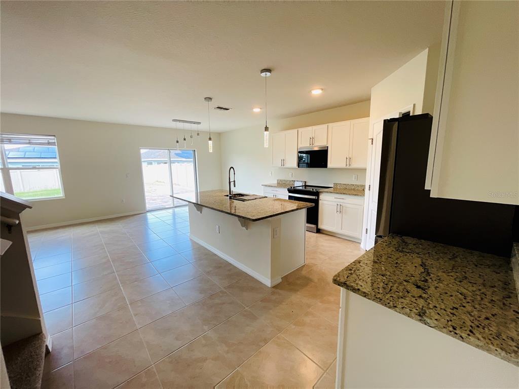 A tiled entryway leads to a white front door with a transom window above — 975 SERCHIO STREET, HAINES CITY, FL