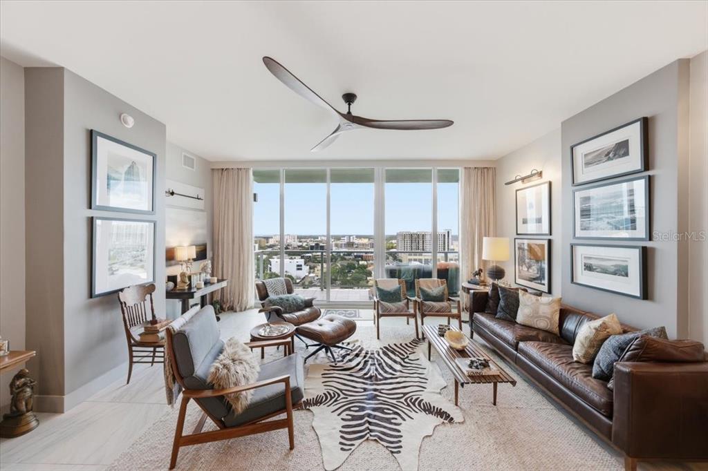 A living room features a leather sofa, zebra rug, and floor-to-ceiling windows with city views — 777 3RD AVENUE N UNIT 1606, ST PETERSBURG, FL