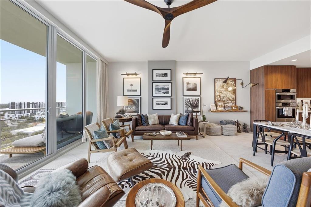 A modern living room features a leather sofa, zebra rug, and large floor-to-ceiling windows — 777 3RD AVENUE N UNIT 1606, ST PETERSBURG, FL