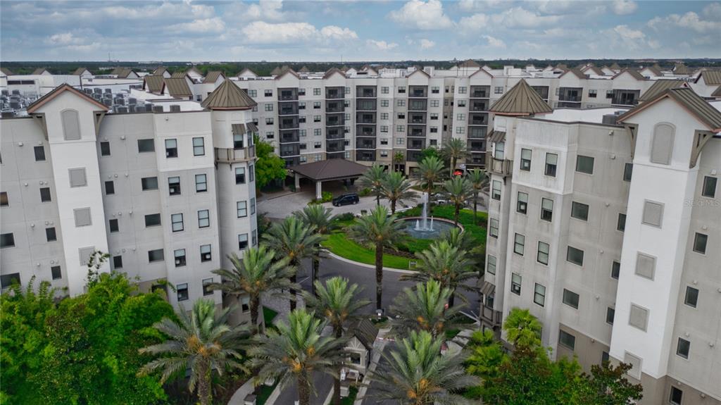 An aerial view shows a multi-story apartment complex with a central fountain and palm trees — 14501 GROVE RESORT AVENUE UNIT 2135, WINTER GARDEN, FL