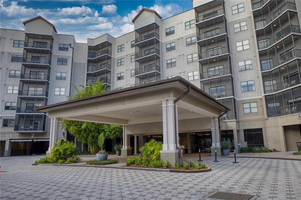 A multi-story apartment building features a covered entrance portico and a paved circular driveway — 14501 GROVE RESORT AVENUE UNIT 2135, WINTER GARDEN, FL