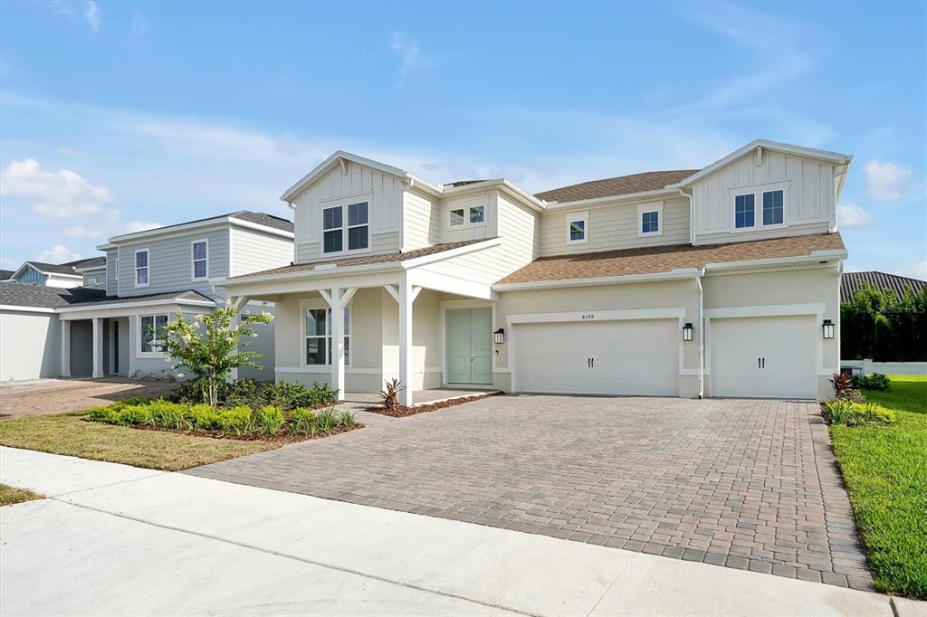 A two-story house with light siding, a paved driveway, and a three-car garage — 8399 PARK CLIFF WAY, ORLANDO, FL