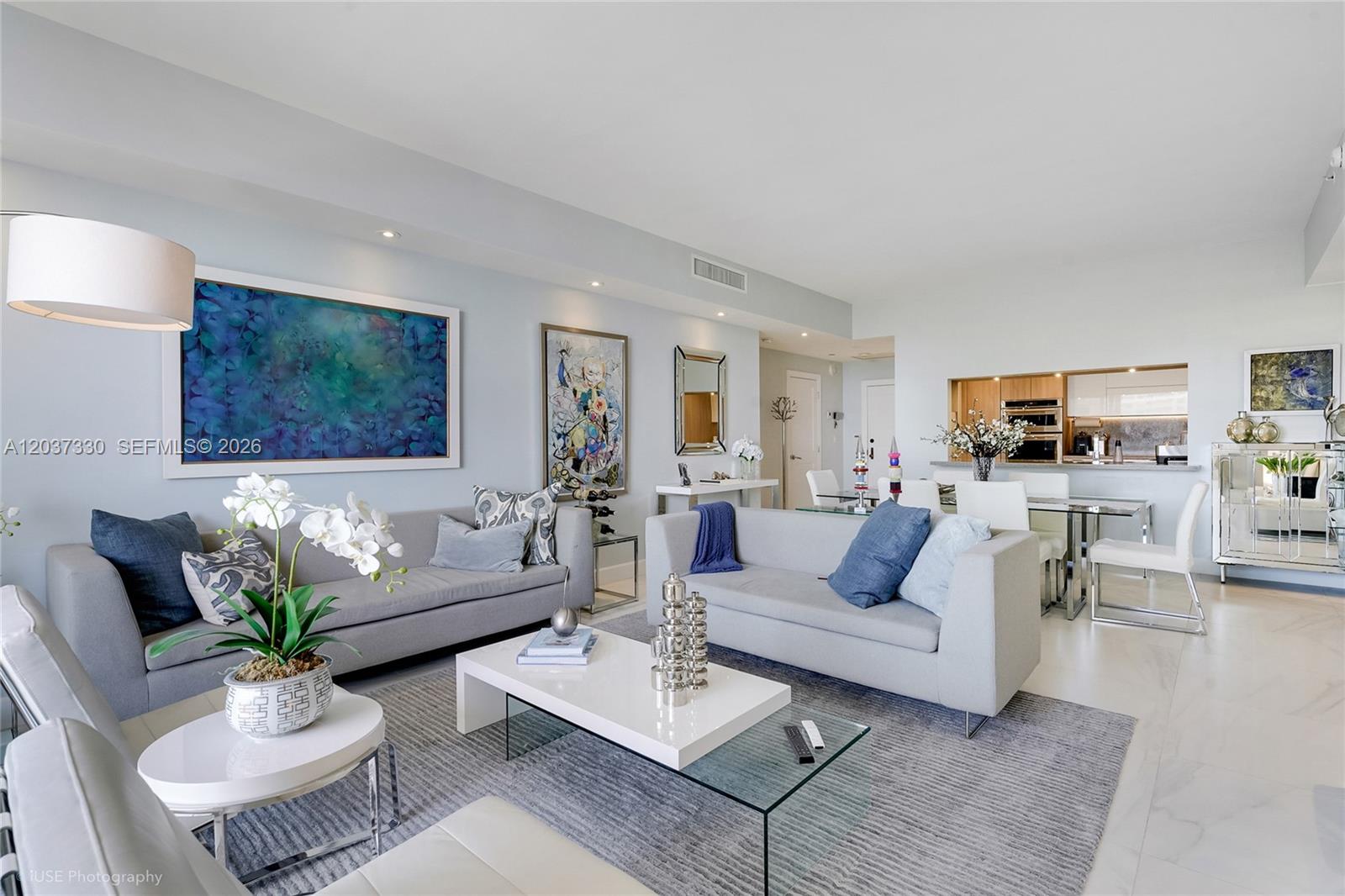 A modern living room features two gray sofas, a white coffee table, and abstract artwork — 201 Crandon Blvd # 833, Key Biscayne FL 33149, KEY BISCAYNE, FL