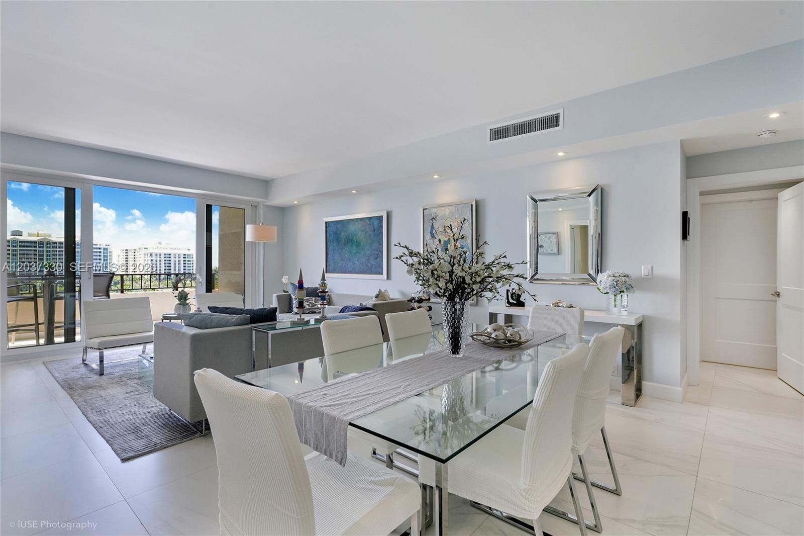 A bright dining and living area features a glass table, white chairs, and balcony access — 201 Crandon Blvd # 833, Key Biscayne FL 33149, KEY BISCAYNE, FL