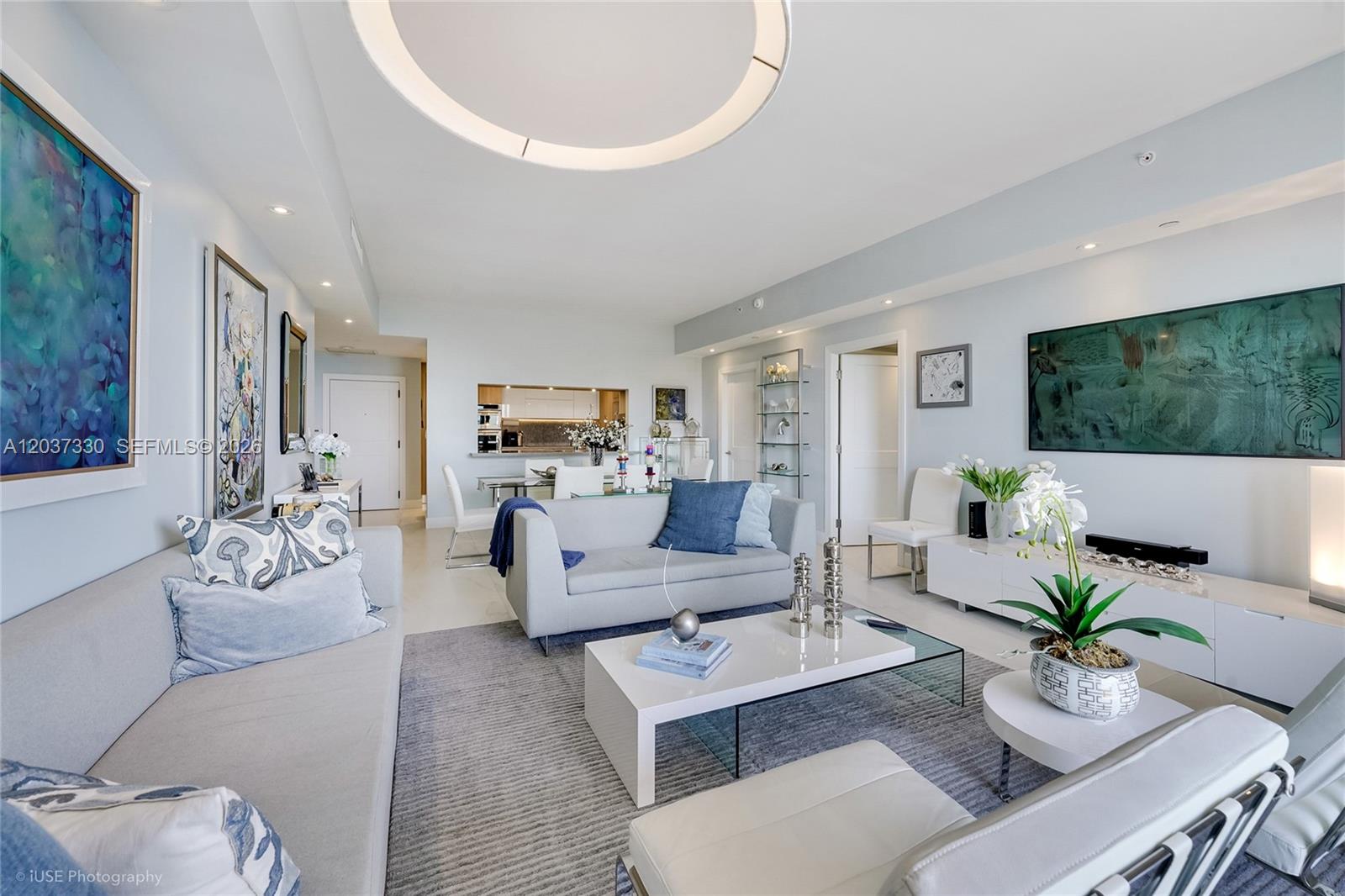 A bright living room features light gray sofas, a white coffee table, and blue accents — 201 Crandon Blvd # 833, Key Biscayne FL 33149, KEY BISCAYNE, FL
