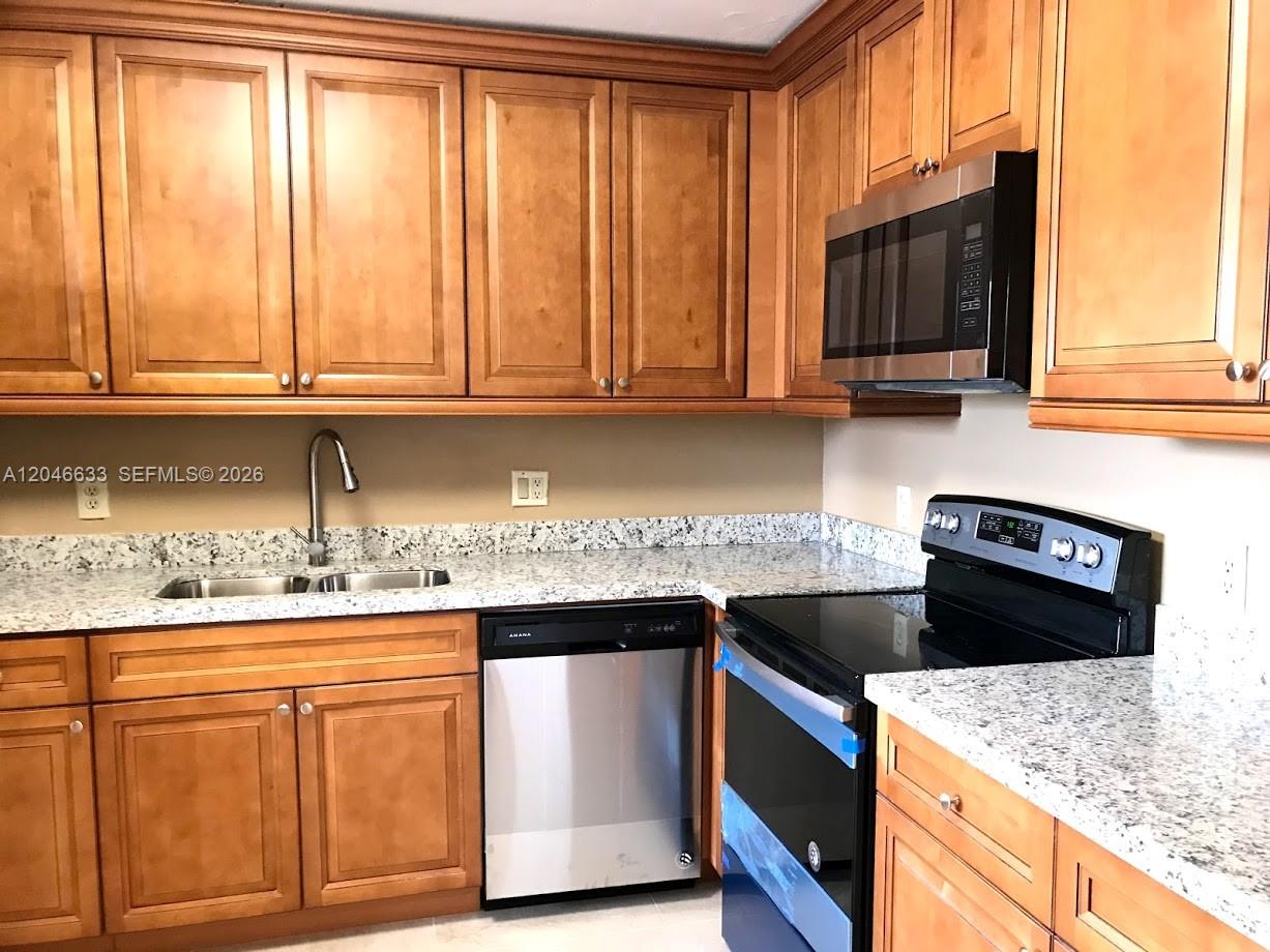A kitchen features wood cabinets, granite countertops, and stainless steel appliances — 369 Lakeview Dr # 203, Weston FL 33326, WESTON, FL