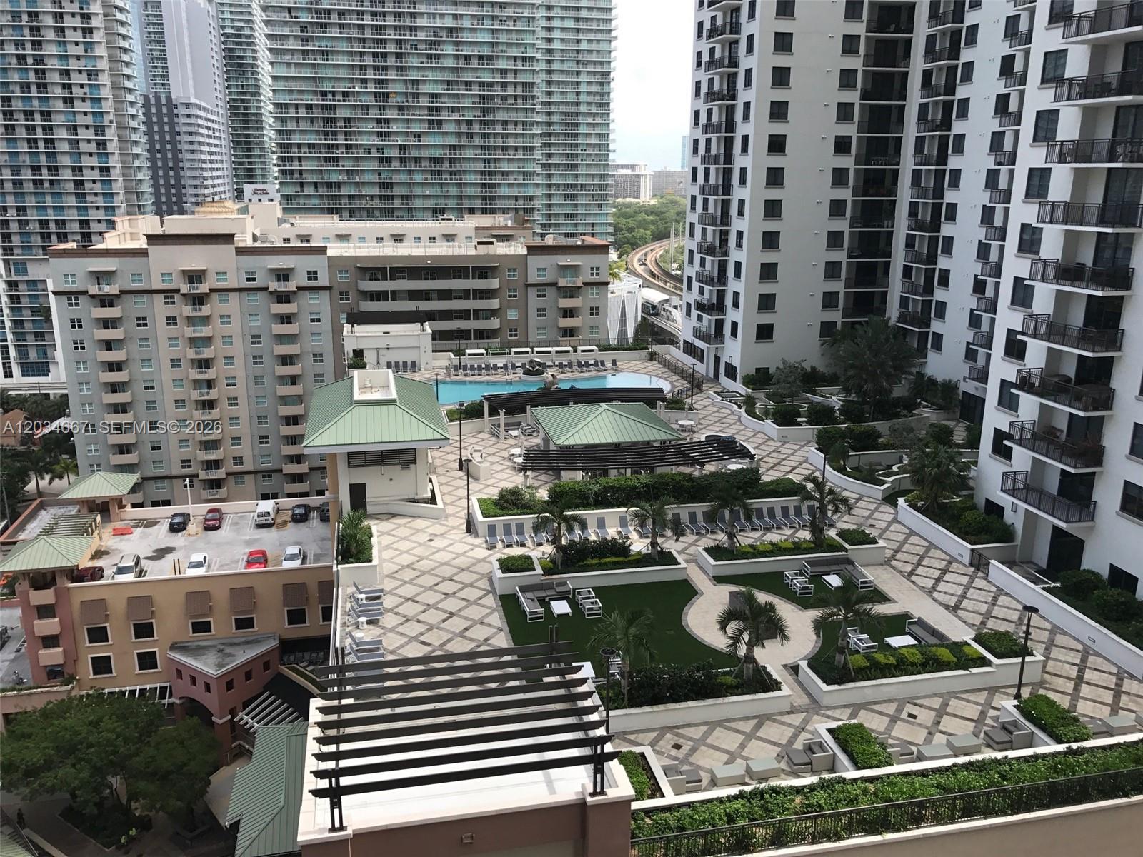 An elevated view of a residential building courtyard featuring a swimming pool and landscaped terrace — 55 SW 9 St # 1605, Miami FL 33130, MIAMI, FL
