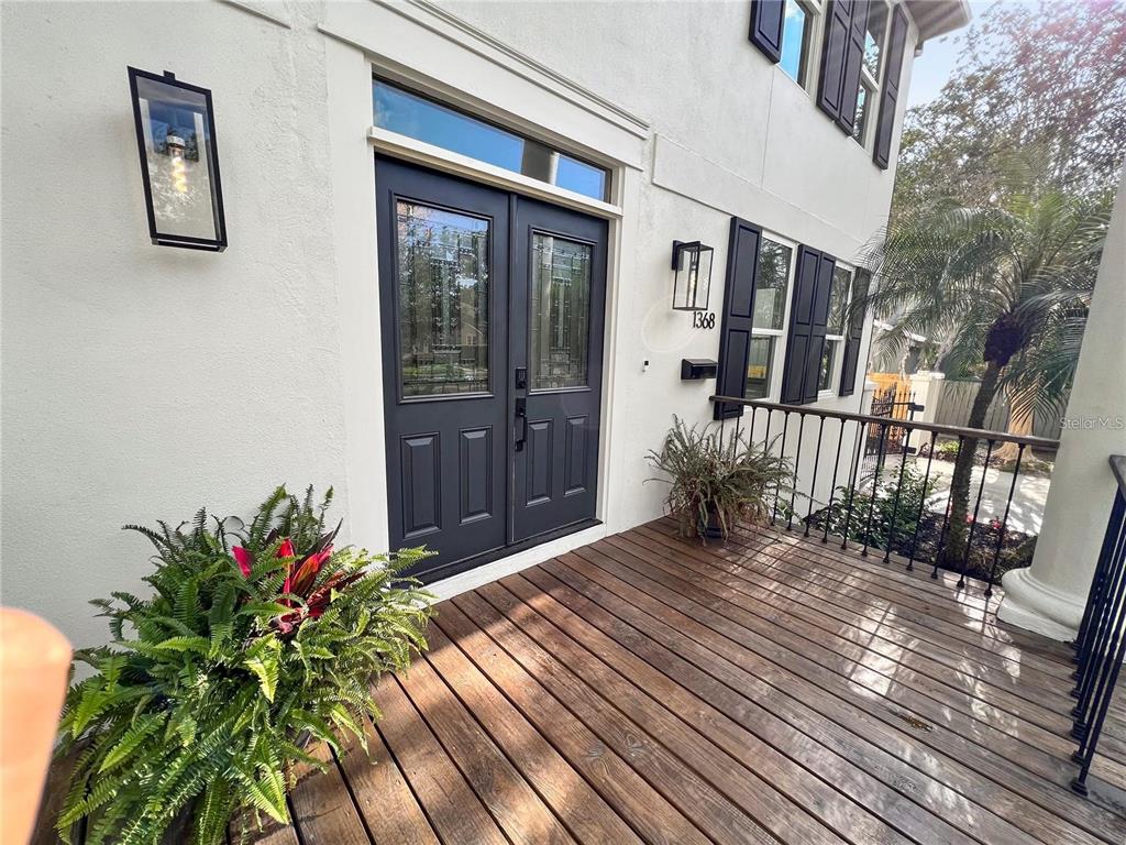 A wooden porch leads to dark double front doors with a transom window above — 1368 HIBISCUS AVENUE, WINTER PARK, FL