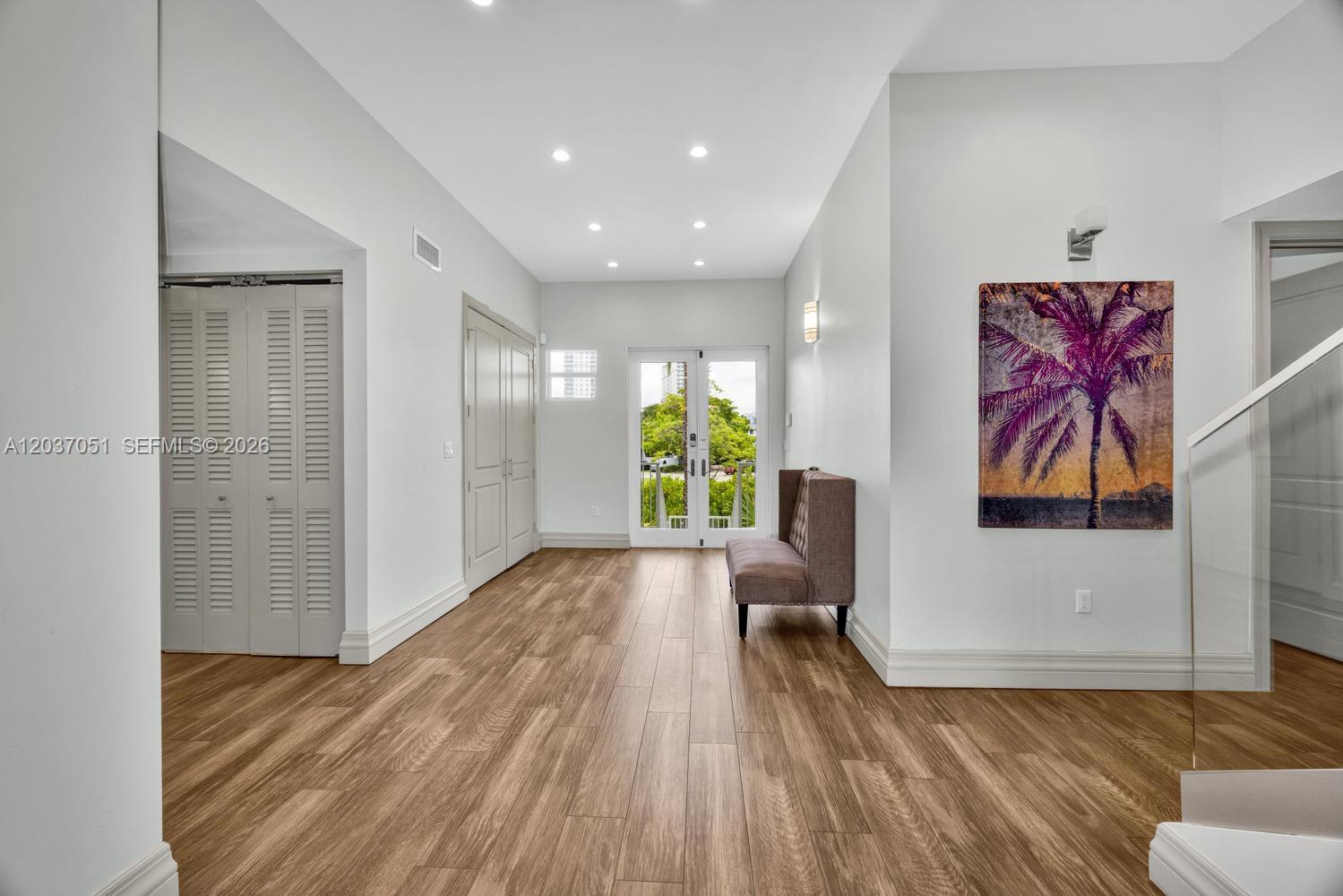 A two-story house with light green siding, a covered ground-level parking area, and front stairs — 1076 NE Little River Dr, Miami FL 33138, MIAMI, FL