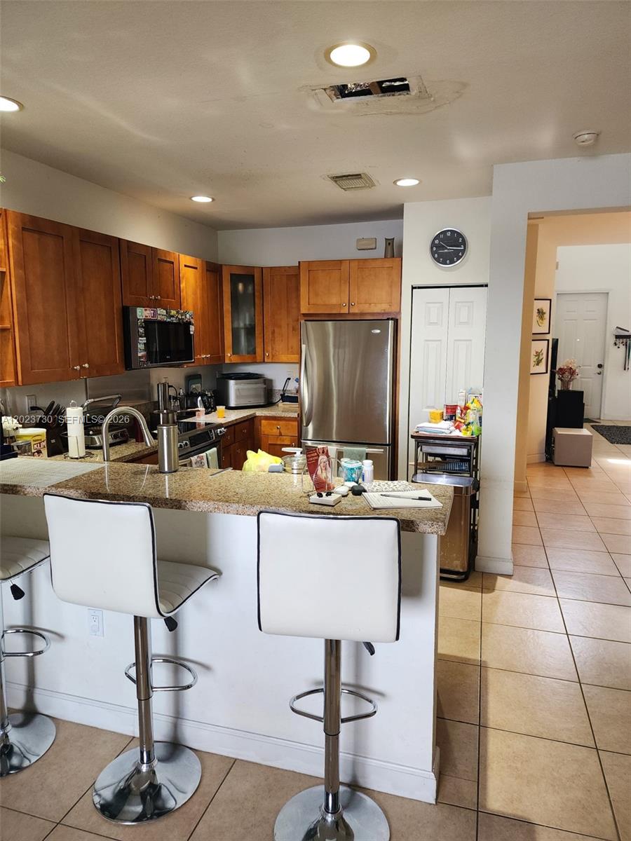 A dining room features a table with a white cloth, chairs, and a sideboard — 7510 NW 107th Pl, Doral FL 33178, DORAL, FL