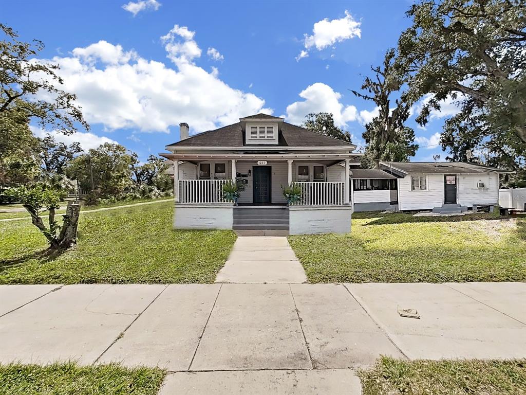 A single-story house with a front porch, white siding, and a detached structure behind it — 601 W BAKER ST, PLANT CITY, FL
